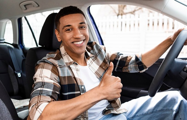 Man smiles in car