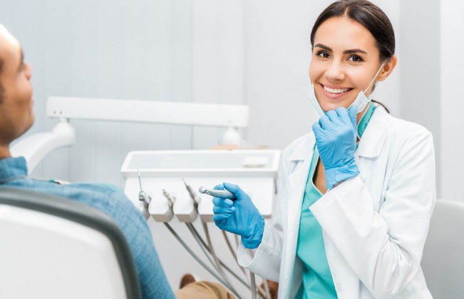 Cosmetic dentist smiling during appointment with patient