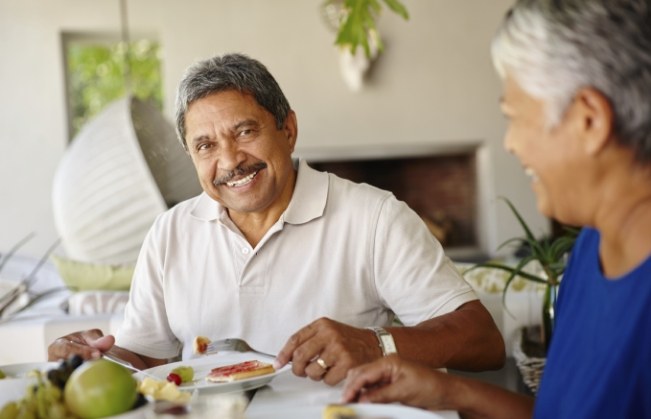 Man smiling and eating a meal