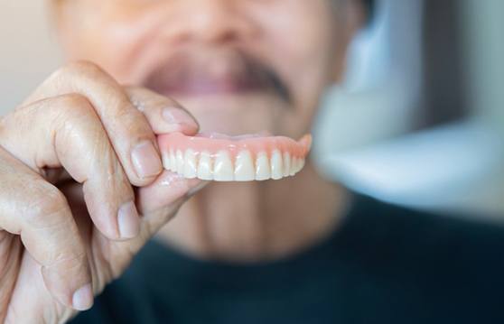 Patient holding their dentures in Renton