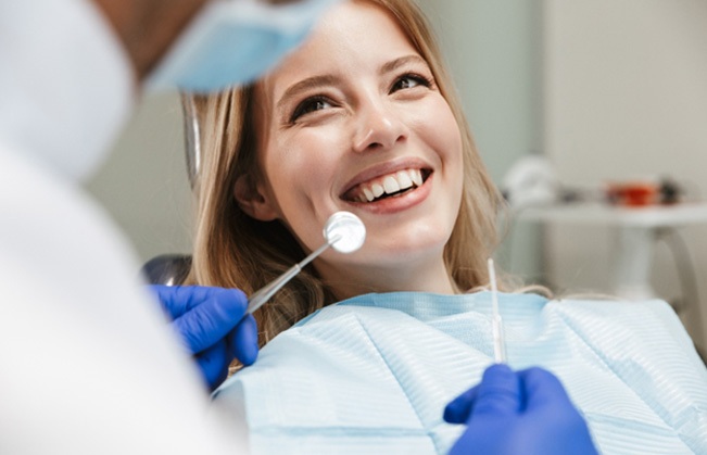 Patient smiling at dentist while sitting in treatment chair