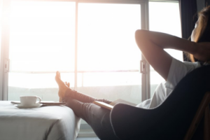 Woman relaxing in a cozy chair by a sunlit window